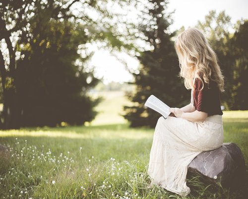 Mature woman reading a book with soft natural light